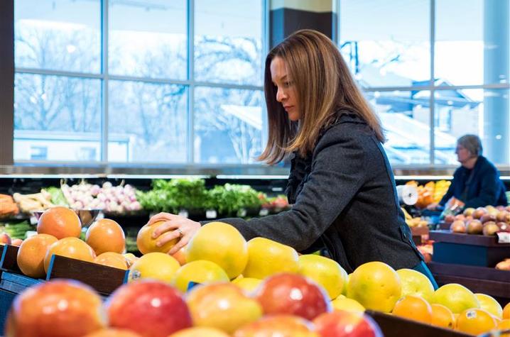 Alison Gustafson picking out produce in a store