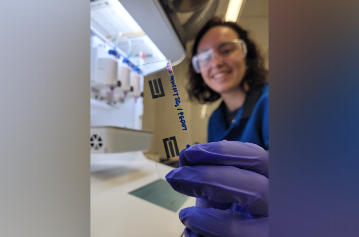 Paula Alarcon-Espejo, a graduate research assistant at UK's Center for Applied Energy Research, holds a slide with a printed carbon nanotube/conducting polymer composite electrode pattern for making a printed OECT.