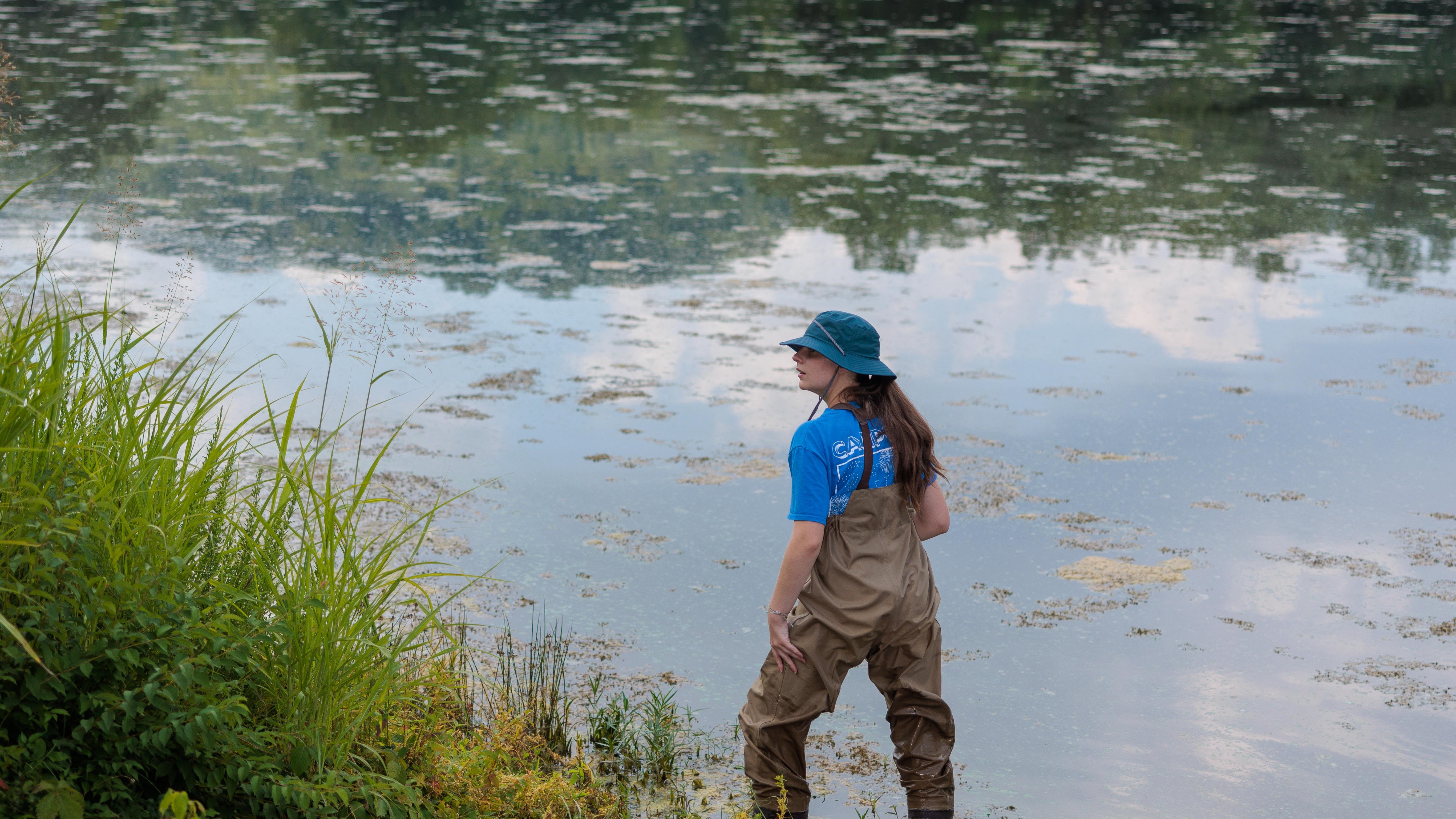 Amanda Beall collecting water samples in a stream.
