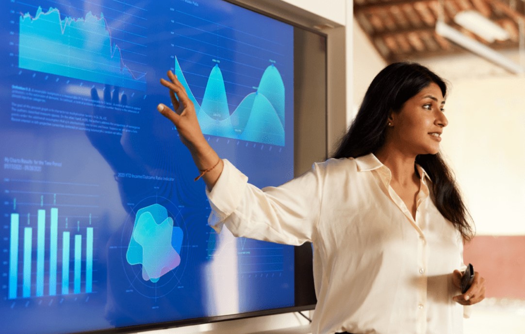 woman pointing to a screen with charts