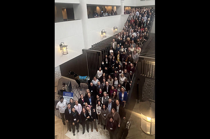 Conference attendees gathered for a group photo on a staircase