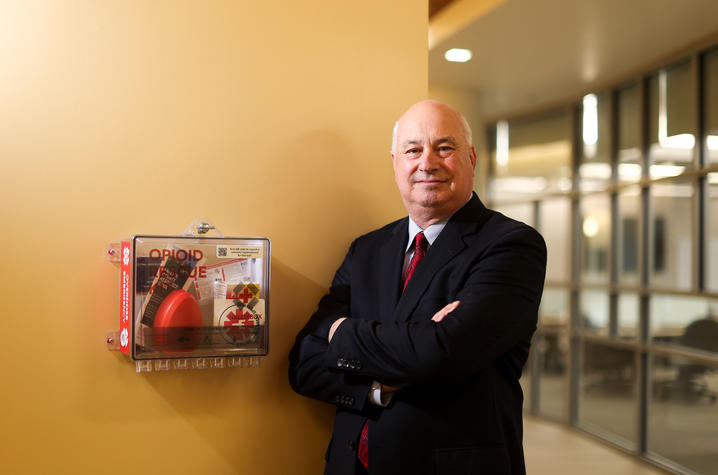 Daniel Wermelin standing next to an emergency opioid rescue box on a wall