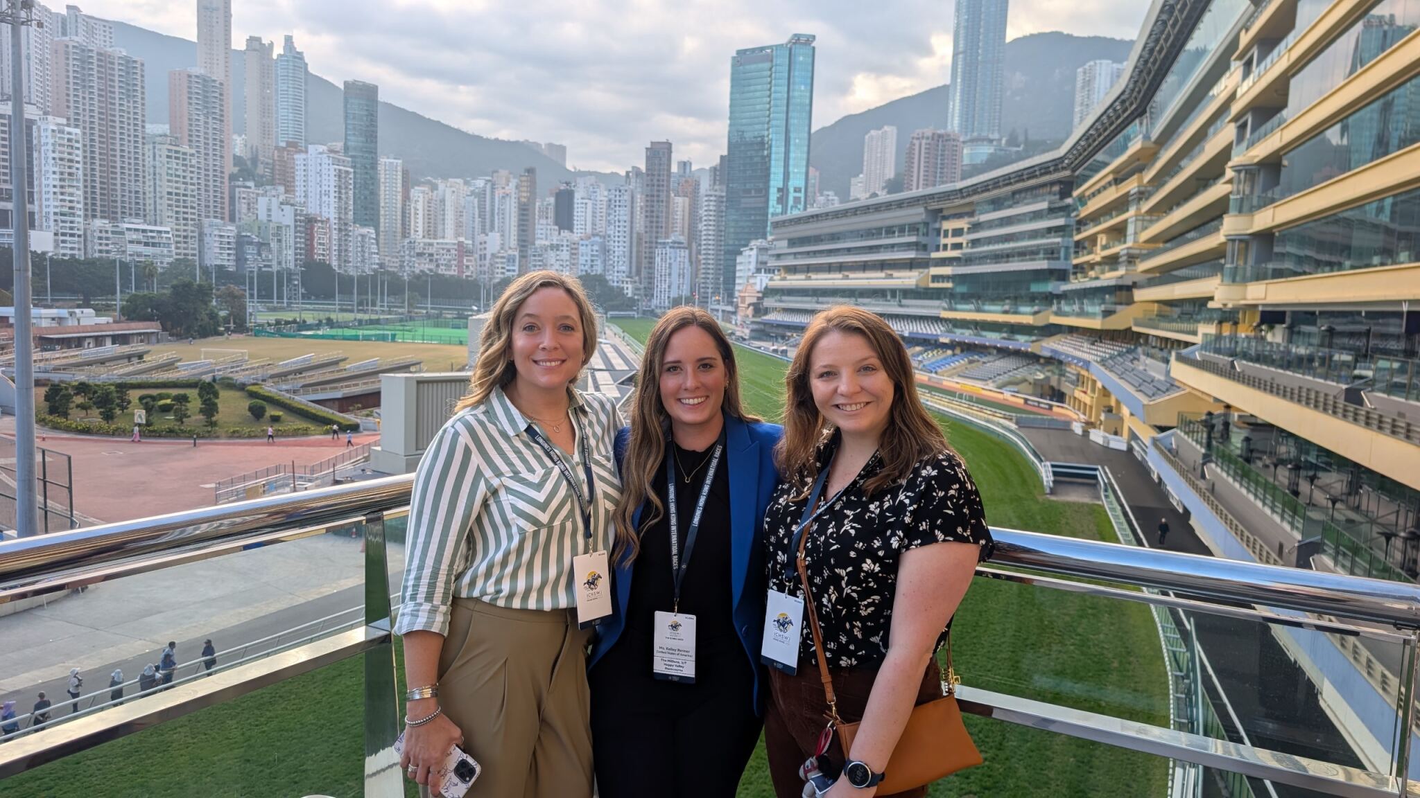 Kelley Renner, Ashley Samson and Michaela Keener standing outdoors above a grass racing track