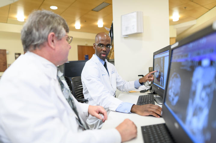 Two doctors examine medical images on a computer