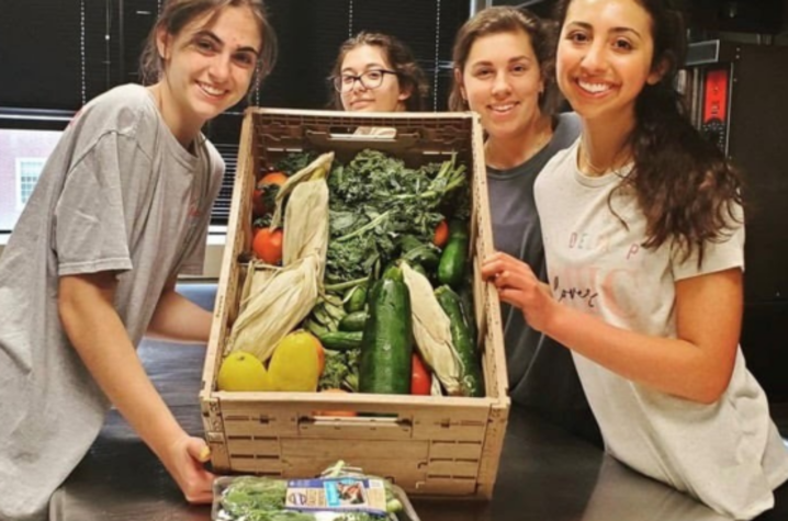 students holding a crate of fresh produce