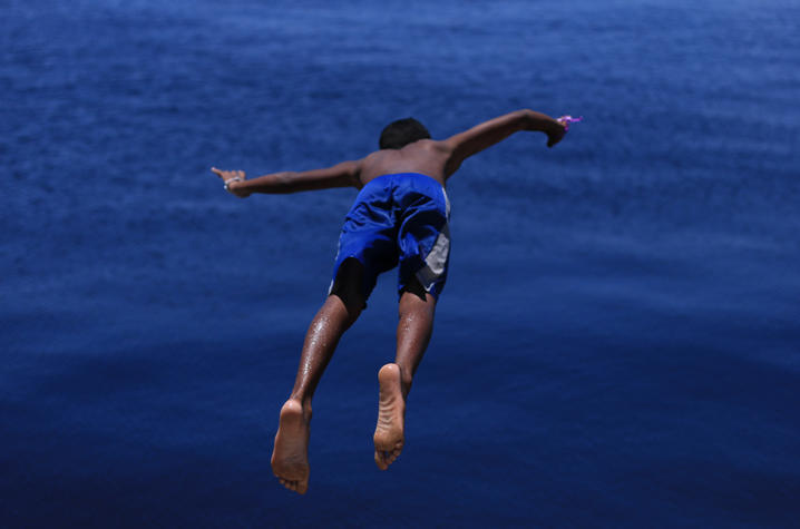 a child in a blue swimsuit dives into water