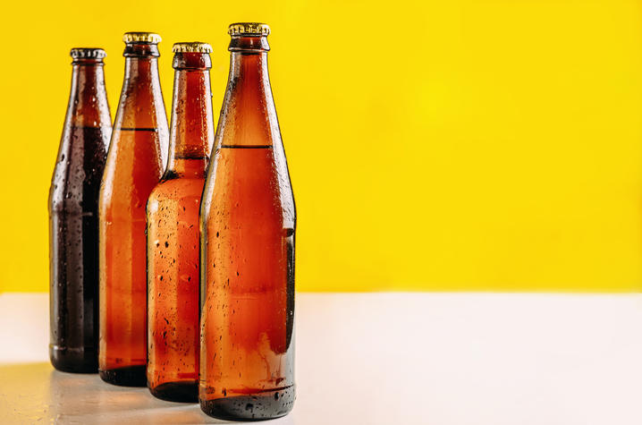 brown bottles lined up against a yellow background