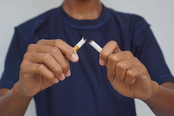 Man breaking cigarette in half
