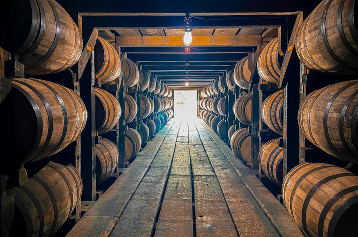 wooden barrels lining the walls of a bourbon rickhouse