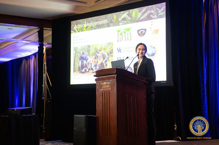 Jaesylin Stephens giving a presentation behind a podium on a stage