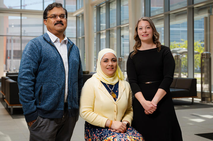 M. Ashfaqual Alam, Yosra Helmy and Lindsay Czuba in a bright glass atrium