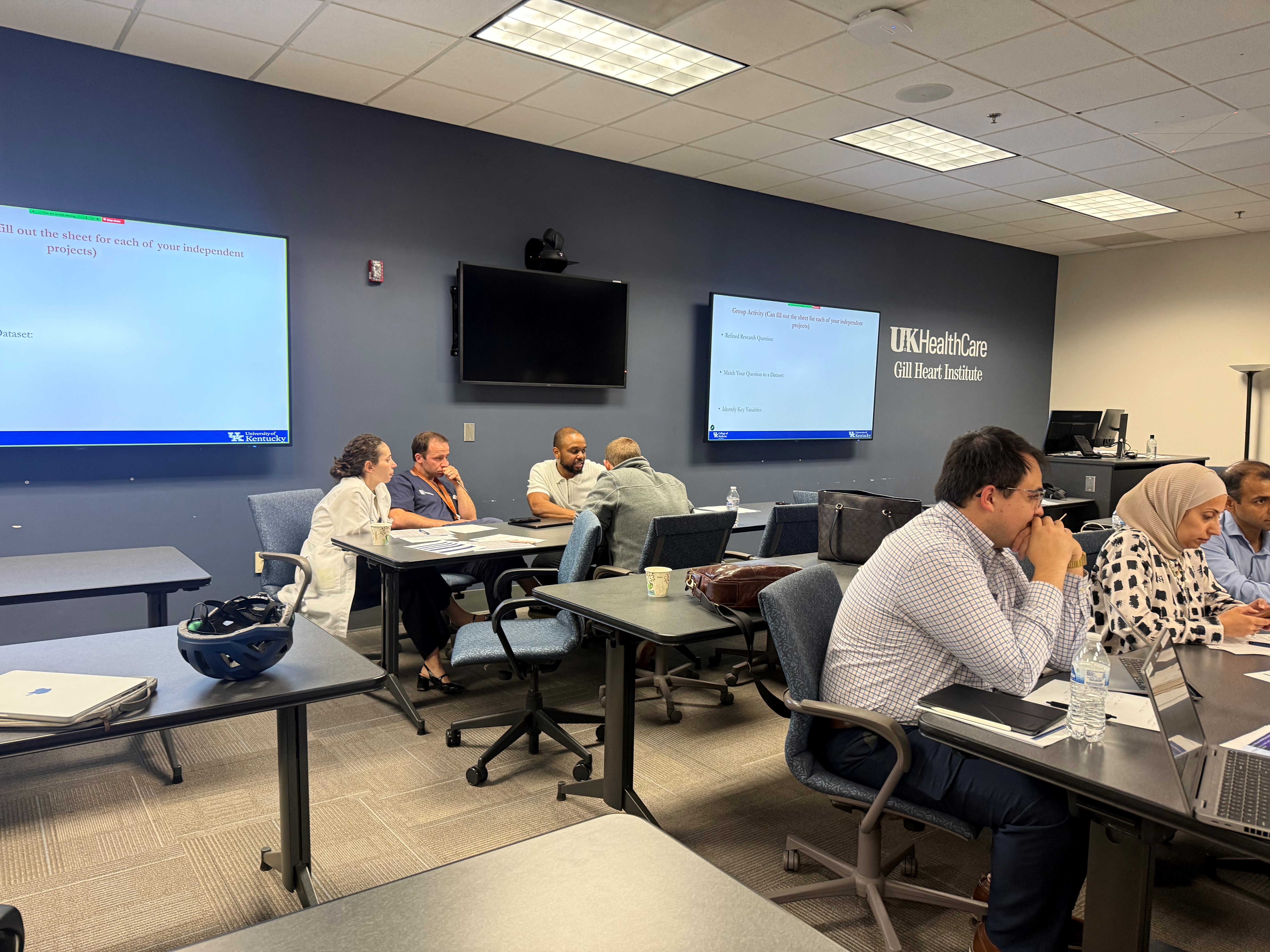 conference attendees sit in a UK HealthCare conference room, working in small groups