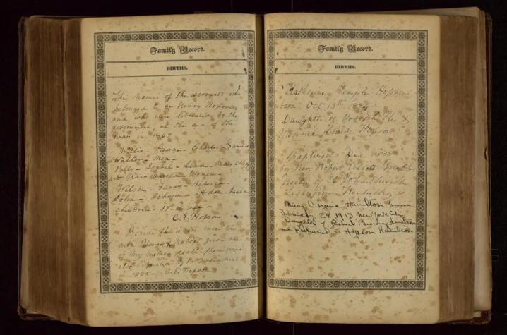 Open historical book with handwritten entries on aged pages, displayed against a dark background.