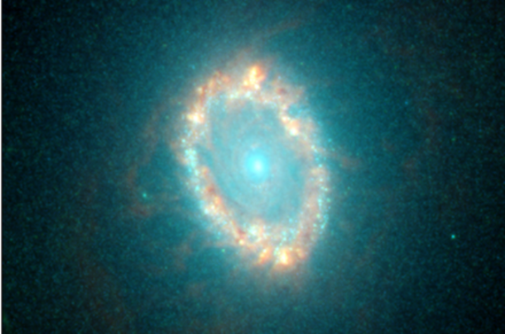 Glowing ring-shaped galaxy with a bright center surrounded by a halo of stars against a dark background.