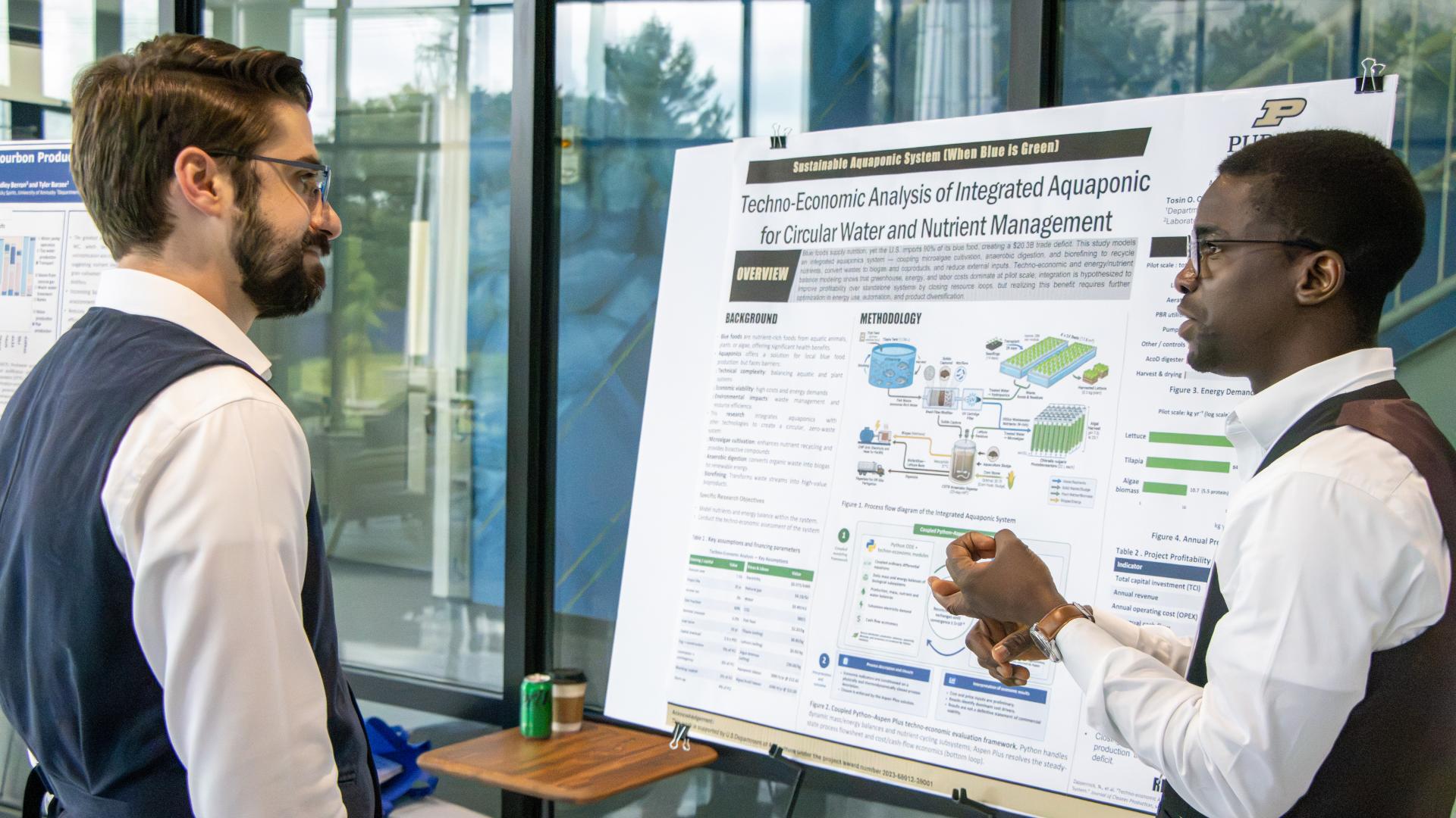 two people talking in front of a research poster