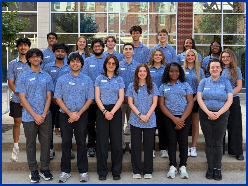 a group of students in matching shirts stand in front of a building