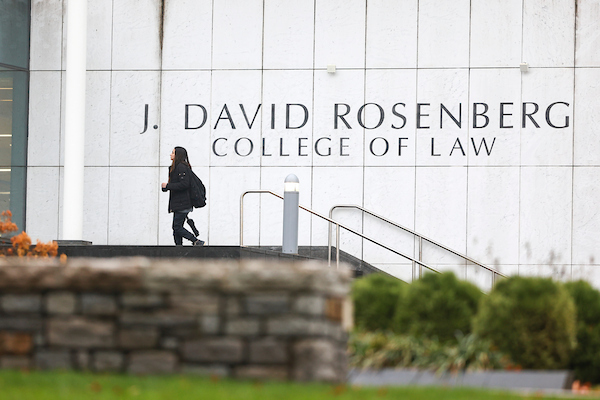 a person walks by the exterior of the J. David Rosenberg College of Law