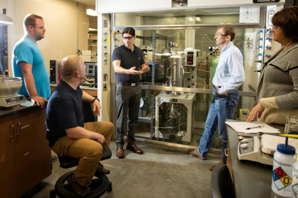 Eduardo Santillan-Jimenez presenting an experiment to others in a lab