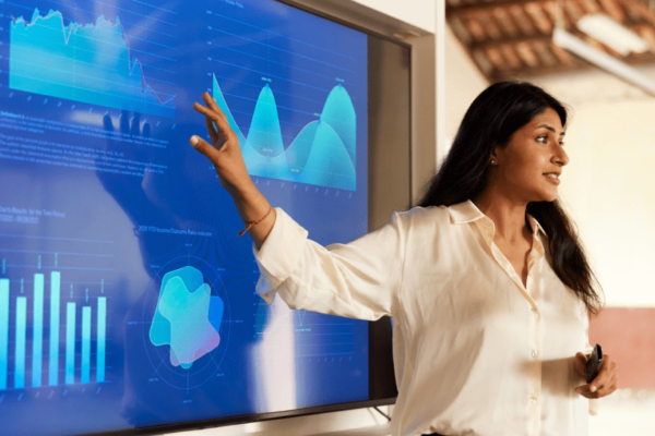 woman pointing to a screen with charts