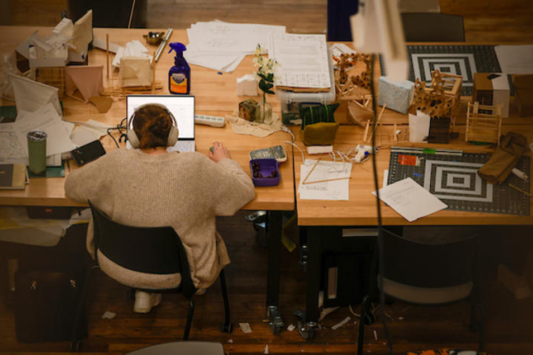overhead image of a student working on their laptop in a design studio