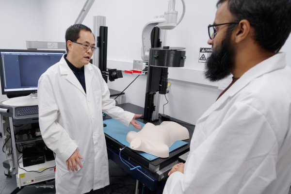 Guoqiang Yu discussing an imaging technique in a lab with another researcher