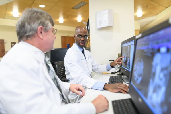 Two doctors examine medical images on a computer