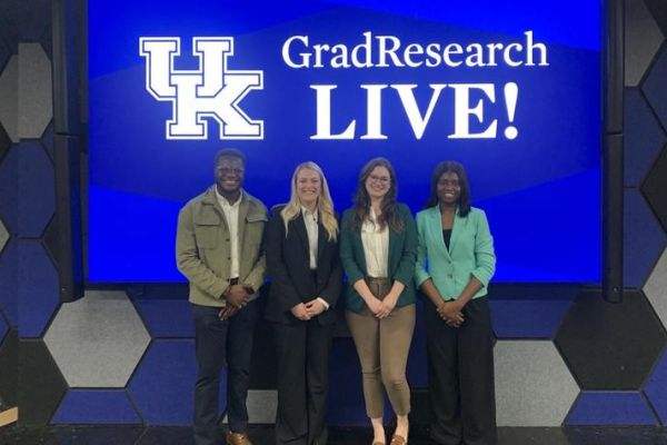 Odianosen Ewah, Courtney Martin, Alyson Ackerman Olivelli and Damilola Petinrin stand in front of the UK GradResearch LIVE! logo
