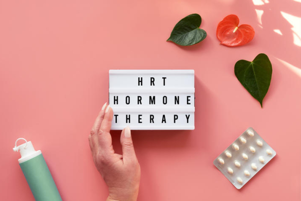 hand holding a sign that reads "HRT Hormone Therapy"