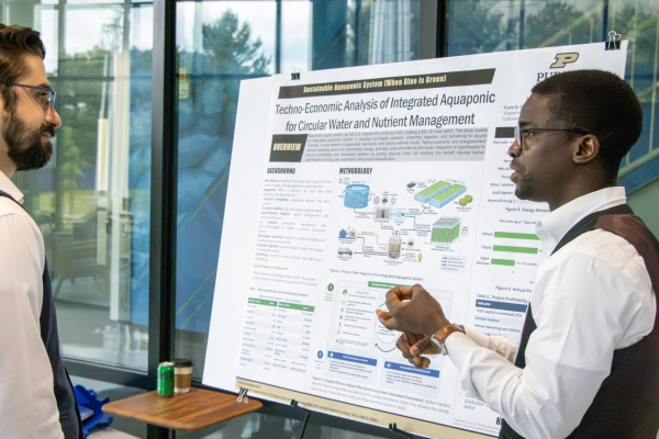two people talking in front of a research poster