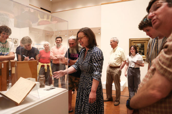 Group tours museum exhibit during gallery discussion.