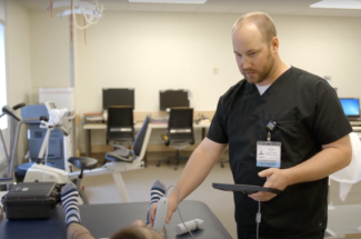 Kirby Mayer, D.P.T., Ph.D., works with a patient. Photo taken prior to COVID-19 pandemic.