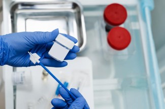 Stock photo of blue gloves holding laboratory equipment.