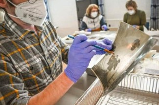 A volunteer at Hindman Settlement School helps restore a photograph following the massive Eastern Kentucky flood in July 2022.