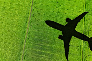 shadow of airplane crossing a green field