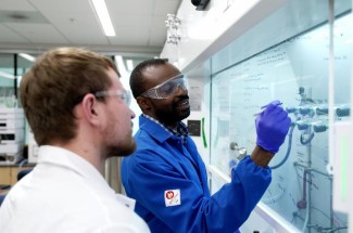 Samuel Awuah, Ph.D., right, works with teaching assistant Justin Holmes in the lab.