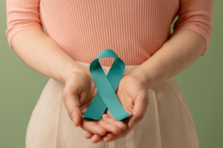 Person holding a teal ribbon