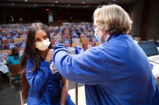 ER nurse Hinali Patel (left) gets her vaccination from Joni Pruitt (right) as UK administered its first round of COVID-19 vaccinations on December 15, 2020.