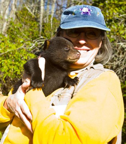 headshot of Carol Spence holding a bear cub