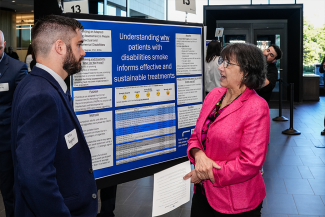 Sean Regnier, College of Medicine postdoctoral fellow, shares his research NIH Director Monica Bertagnolli. His work is focused on understanding why patients with disabilities smoke to inform effective and sustainable treatments.