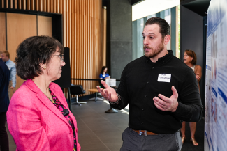 Ryan Shahidehpour, College of Medicine graduate student, shares his research on how microglia mediate the spread of Alzheimer’s with NIH Director Monica Bertagnolli.