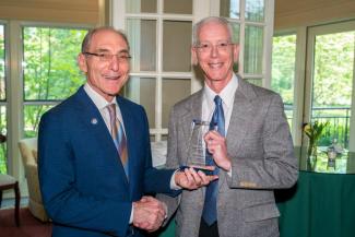 Craig Miller accepting the award from President Capilouto.