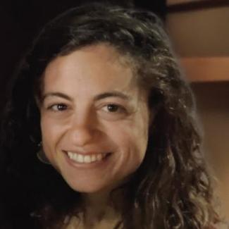 Image of Melody Altschuler, a white women with dark brown curly hair and brown eyes.