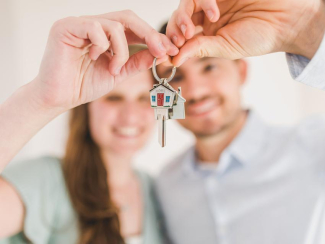couple holding keys to a home