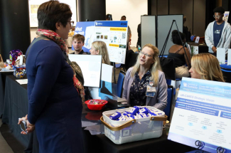 Leslie Anaskevich, representing UK HealthCare, speaking with an attendee along with Kristy McMillan, right,
