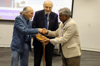 From left, Richard Levine and Ernie Yanarella present Ibrahim Jawahir with the Yanarella Levine Legacy Award