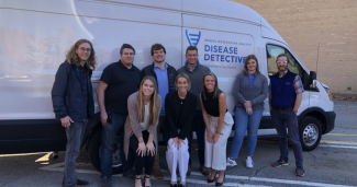 Researchers near the Disease Detectives van