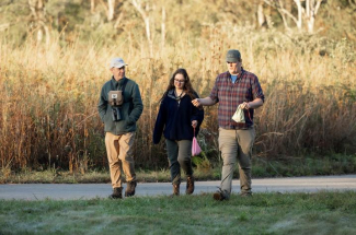 researchers walking among tall grass at Raven Run