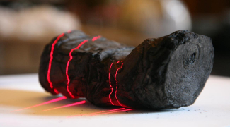 an ancient, blackened scroll is being scanned by lasers
