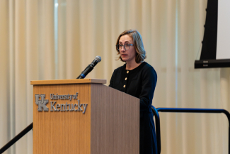 Emily Mokros speaking behind a University of Kentucky podium