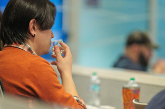 a person sniffing a bourbon sample